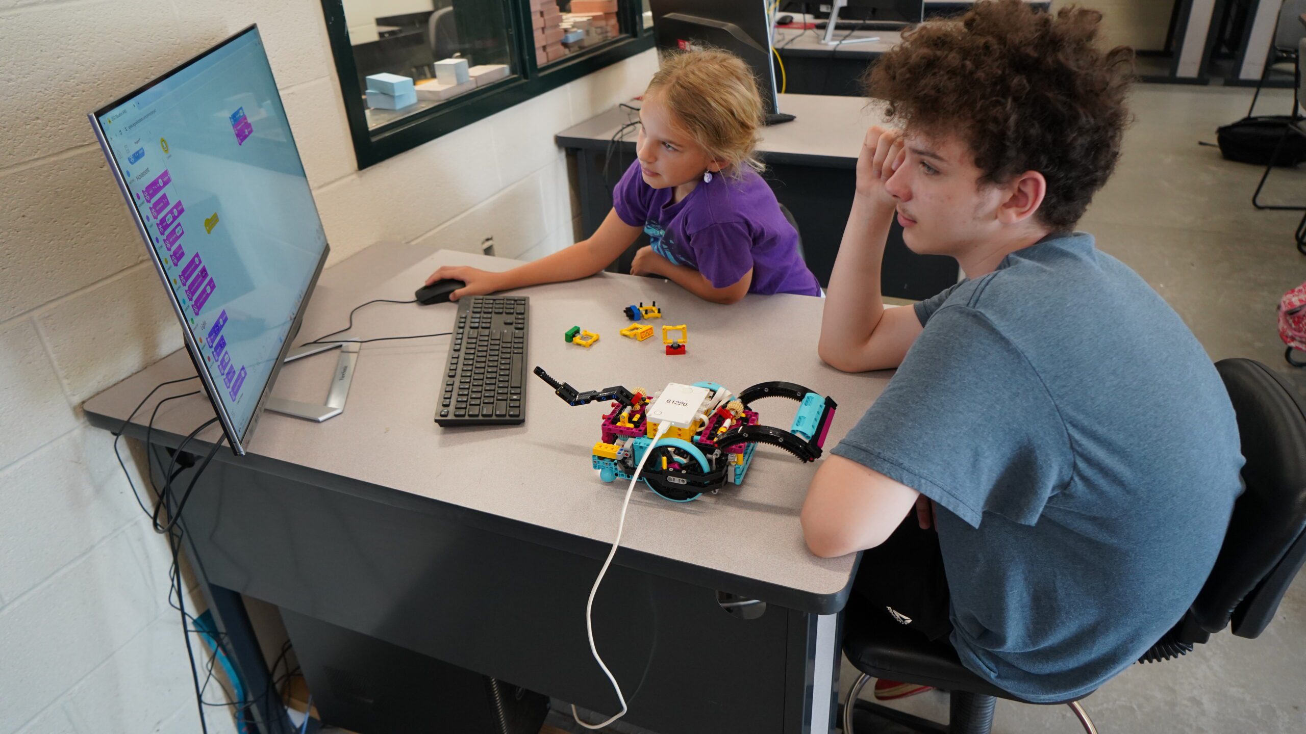 A pair of students work together to code a LEGO SPIKE robot